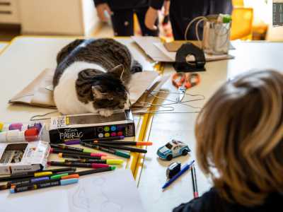 Prima di salutare i piccoli, facciamo la conoscenza con la mascotte di Villacolle: assopita fra fogli e colori c�� infatti Tita, una gatta bianca e grigia che, nonostante le chiacchiere dei bimbi e i rumori di fondo, si riposa sui banchi come una piccola sfinge